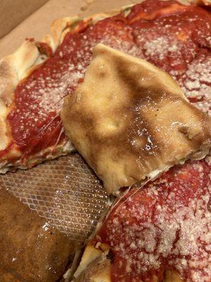 Close up of a grease soaked box and the underside of a grease soaked crust