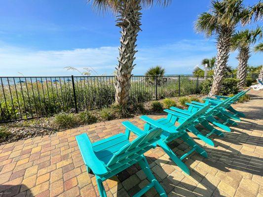 Chairs on the pool deck looking out at the ocean.