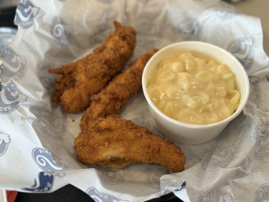 Chicken strip with a mac and cheese side.