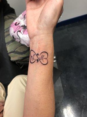 My friends tattoo. Suicide awareness semi-colon with her nieces initials. It looks like a butterfly!