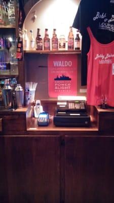 The sign behind the bar reads "Waldo congratulates you on avoiding the power and light district"