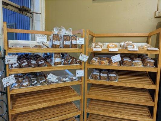 Loaves of quick bread, individually-wrapped muffins/scones, cinnamon snacks, and stacks of cookies are available.