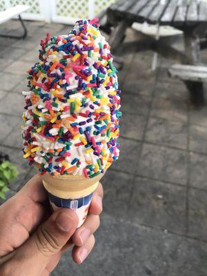 Soft serve vanilla cone with rainbow sprinkles