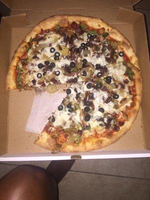 A veggie pizza with bacon and steak And a buffalo chicken pizza