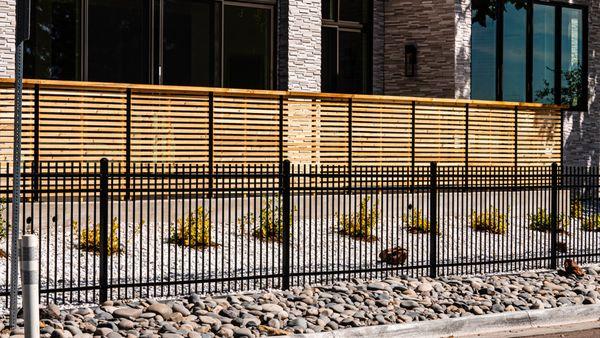 This is a spaced horizontal fence with top cap along with a 4 foot Genesis metal perimeter fence!