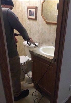 One of our workers steam cleaning the sink to remove grime and mold