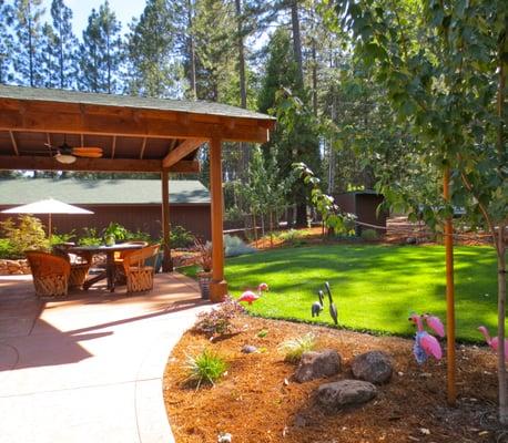 Grass Valley front yard upgrade: stamped concrete patio, covered porch, irrigation, rock wall, planting, lawn (pink flamingos not included).