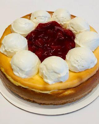 Whole cheesecake topped with strawberry glaze and fresh-made whipped cream.