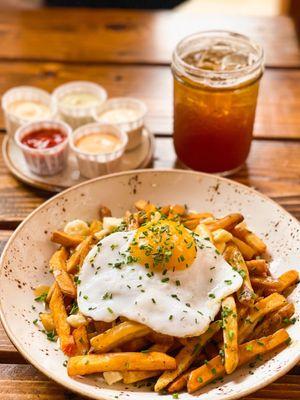 Poutine with an added duck egg, sauce flight, and root beer