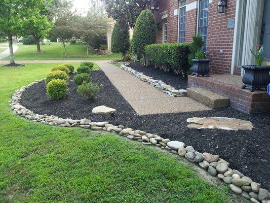 We installed the river rock landscaping edge, hedged, and mulched all front beds