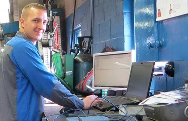 Martin Automotive mechanic uses a computer to fix a vehicle.