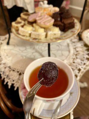 A sugared grape with the tray of treats behind it