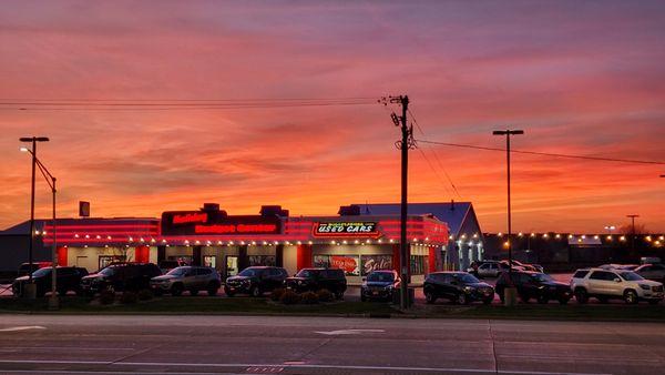 A beautiful sunset descends behind the retro-inspired Budget Center facility.