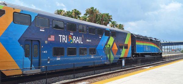 This is a northbound Tri-Rail coach and locomotive at Fort Lauderdale (MIA to West Palm Beach route) with some palm trees beyond.