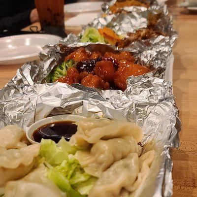 Steamed pork dumplings, Orange chicken, Teriyaki chicken, and walnut shrimp.