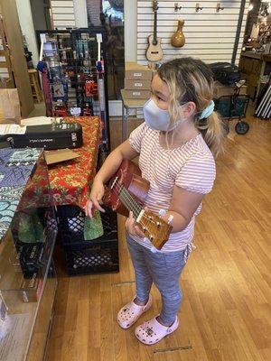 Getting her first feel for ukulele with a crash course from Max.