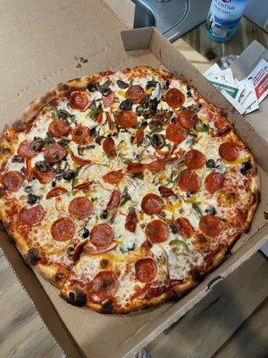 Supreme pizza with mushrooms on half