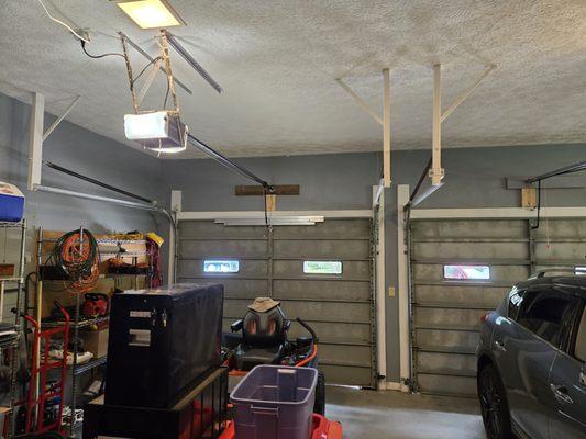 Old junk aluminum doors with tension springs and 2x4 support posts nailed into attic joists