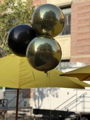 floating gold and black round foil balloons