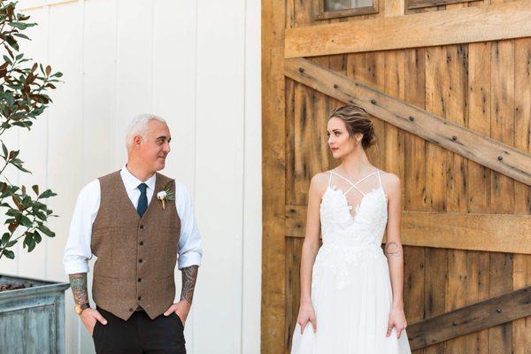 Bride & Groom in front of the barn doors. Photo by @MaryFoskyPhotography