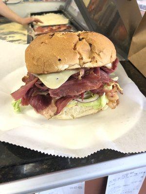 super pastrami sandwich on a buttered onion roll