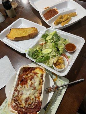 Prefrozen tasting Lasagne, wilted salad, burnt and old garlic bread, prefrozen over breaded cheese sticks