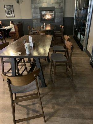 High-ish tables with surprisingly comfortable chair/stools. Gas fire in the background.