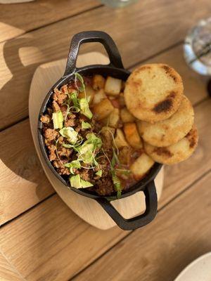 Vegan Shakshuka - potatoes and vegan chorizo instead of the eggs. Vegan arepas on top