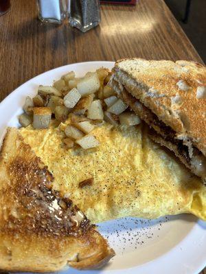 Sausage & cheese omlette with home fries and sourdough toast.