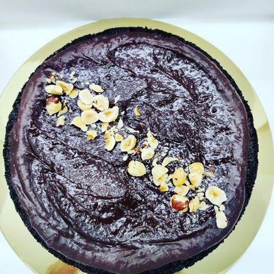 Gluten free and vegan triple chocolate cake with dark chocolate and fig ganache. Topped with hazelnuts