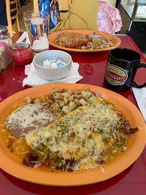 Large omelette with all the veggies, added green chili on top, home fries and refried beans. Hers is red chili breakfast enchiladas