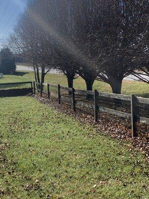 Leaves cleaned up with natural weed block around fence posts