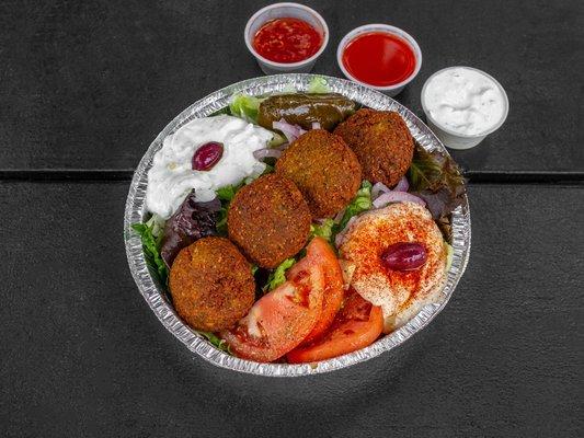 Homemade falafel and hummus gluten free served over a Greek sald or rice and salad