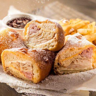 Monte Cristo: Smoked ham, smoked turkey, 2 cheeses, battered & fried until golden w/raspberry preserves & dusted w/powdered sugar, w/fries