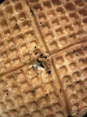 Dirty debris or black burn from unclean waffle maker.