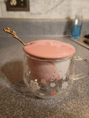 Glass tea cup with ceramic strainer and golden spoon