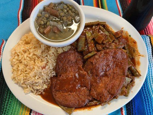 Tortitas de camarón served with nopalitos cooked in Chile Colorado and a side of lentejas y Spanish Rice.