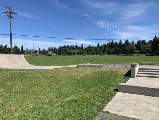 Part of the skate park and grassy fields.