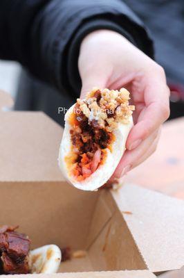 Inside of Spicy Pork Bao - gochujang pork shoulder, vinegar slaw, onion crisps, mayo