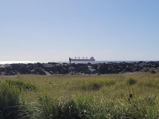 Cargo ship passing by, black shadow is a 5'8" man