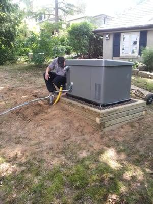 After building the treated wood base and filling it with gravel, the generator was set.  Making the gas connection is next.