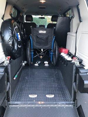 View of wheelchair in van and ramp in position.