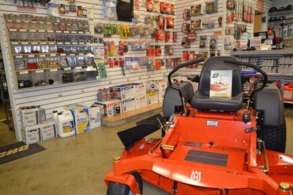 Husqvarna zero turn with just a few of our many oils and parts in the background.