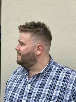 A skin fade with a textured scissor hair cut on top. Straight razor line up with the use of color enhancement.