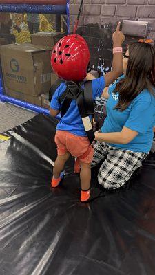 He loves trying the rock climbing wall but he didn't make it to the bell, maybe next time!