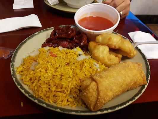 Spare ribs with rice, chicken, and an egg roll.