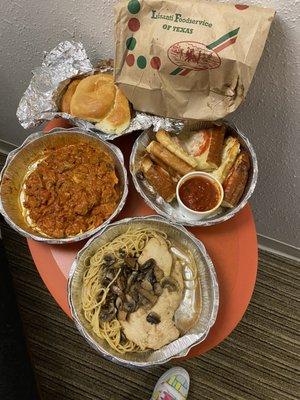 Breadsticks with marinara, spaghetti with chicken to the left and in the front is the chicken Marsala. The rolls are in the foil.