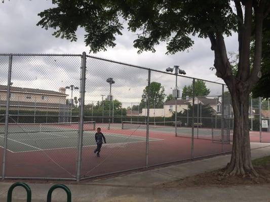 Two large tennis courts with night lights