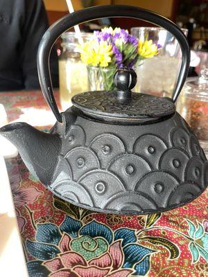 Pot of hot green tea served in an ornate tea pot making me feel pampered.  I LOvED the colorful table clothes and fresh flowers!