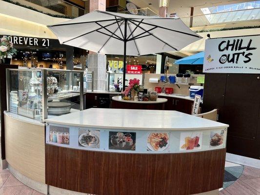 Circular counter in center of the mall 1st level near escalators & food court